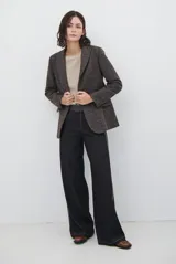 Blazer de paño con estampado de cuadros, corte clásico con hombreras, cierre frontal con botón y botones en los puños. Incluye forro interior y bolsillo interno.
