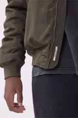 Campera bomber color verde militar con cierre frontal, bolsillos laterales con solapa y bolsillo en la manga izquierda.