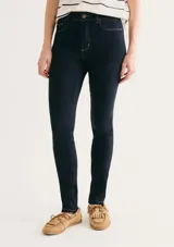 Pantalón de jean corte skinny, de tiro medio y color azul oscuro con costuras en contraste.