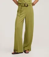 Pantalón pantalona color verde oliva, confeccionado en tejido orly con viscosa certificada. Presenta trabillas largas en la cintura, cierre tradicional, bolsillos y frisos delanteros. Incluye cinturón largo de tejido con hebilla irregular.