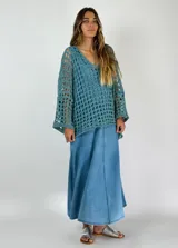 Top tejido al crochet color celeste, con escote en V y mangas largas acampanadas.