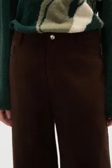 Pantalon de corte recto y tiro medio, confeccionado en tejido de poliester con acabado mate. Presenta bolsillos laterales y cierre frontal con botón metálico.