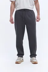 Pantalón de jogging con corte recto y ajuste relajado, confeccionado en tejido de algodón y poliéster. Cuenta con cintura elástica con cordón de ajuste y bolsillos laterales funcionales.