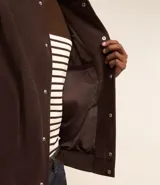 Campera bomber azul marino de pana con cuello redondo, cierre con botones a presión, bolsillos laterales y puños y cintura elastizados.