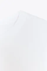 Jersey de punto fino con cuello redondo y manga corta, con terminaciones en rib en cuello, mangas y ruedo.