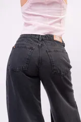 Jeans wide leg de denim rígido en color gris oscuro con lavado ácido. Presenta tiro medio-alto, bolsillos clásicos y corte amplio de caída relajada.