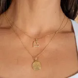 Conjunto de collar en oro 18k compuesto por una cadena fina de eslabones y un dije en forma de corazón con incrustaciones de circonias.
