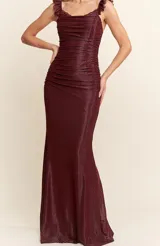 Vestido largo de corte sirena confeccionado en tejido brillante y elástico. Presenta un diseño ajustado con frunces en el torso, escote cuadrado y breteles con detalle de encaje tipo eyelash.