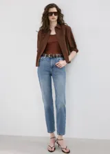 Pantalón de jean de corte recto y tiro medio, con diseño clásico de cinco bolsillos y cierre frontal con botón y cremallera. Presenta un acabado en tono azul medio con sutiles desgastes.
