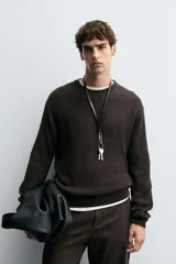 Sweater de punto en canalé color negro, de corte regular fit, cuello redondo y manga larga con terminaciones en rib.