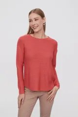 Sweater de punto color salmón, con cuello redondo y mangas largas.