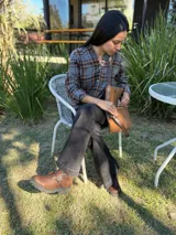 Botas cortas de cuero color marrón con suela track negra. Presentan dos correas ajustables con hebillas metálicas plateadas en el empeine y cierre lateral interno.