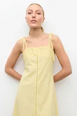 Vestido midi negro con tirantes ajustables mediante lazos, escote recto y detalle de encaje bordado en el pecho y en el ruedo.