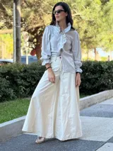 Pantalón ancho color crudo con pespuntes en marrón chocolate, confeccionado en tela con mezcla de jean y lino.