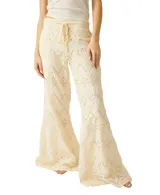 Pantalón de broderie color blanco, de pierna ancha, con cordón ajustable en la cintura y diseño calado con patrones geométricos.