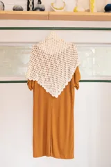 Chal triangular tejido a mano con la técnica de crochet, color crudo.