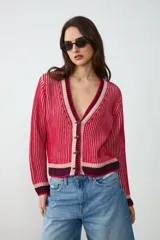 Cardigan de punto con escote en V y cierre frontal de botones. Diseño rayado en tonos rojo, rosado y azul marino, de manga larga.