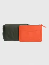 Cartera tipo bandolera Hush Puppies en color verde oliva, con solapa frontal y logo metálico de la marca. Cuenta con una correa ajustable de diseño bicolor con detalles de la marca.