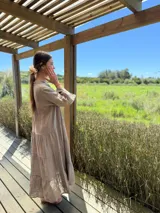 Vestido largo color verde oliva, de lino, con corte amplio, cuello mao, escote en V y mangas largas acampanadas.