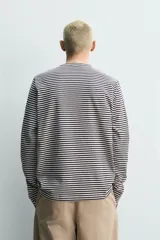 Remera manga larga de corte regular fit, con diseño de rayas horizontales en color azul marino y blanco, cuello redondo y un bolsillo aplicado en el pecho.
