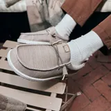 Zapatos Hey Dude Wally Stretch Mesh color beige, con cordones elásticos y suela blanca con motas de colores.