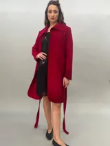 Tapado rojo de lana merino afieltrada, corte recto con lazos para ajustar en la cintura y cuello alto con posibilidad de cruzar los lazos alrededor. Tiene bolsillos laterales.