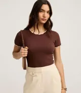 Top de manga corta ajustado al cuerpo, color marrón oscuro, con cuello redondo y bordes festoneados en color crema o beige claro.