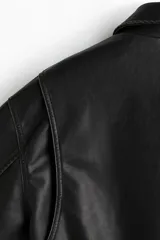 Campera negra de tejido revestido con cuello, cierre frontal y bolsillos laterales. Cuenta con puños y bajo con elástico revestido.