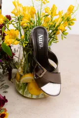 Sandalia color beige con tiras cruzadas y hebilla metálica cuadrada. Taco cuadrado de 6 cm.