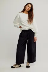 Pantalón de denim blanco de tiro medio con cintura elástica ajustable mediante cordón, bolsillos plaqué delanteros y diseño de corte amplio y holgado.
