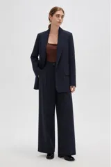 Blazer de corte holgado con diseño de rayas verticales, cuello solapa y cierre frontal con un botón. Presenta bolsillos laterales con solapa y mangas largas.