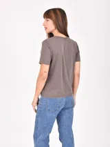 Remera de algodón color negro con efecto lavado, cuello redondo y mangas cortas con terminación al corte.