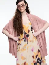 Chal tejido en hilado liviano color rosado con brillo sutil y pequeñas lentejuelas al tono. Diseño envolvente y fluido.