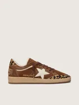 Zapatillas Golden Goose modelo Ball Star, confeccionadas en gamuza marrón con detalles en animal print de leopardo en la puntera y el talón. Presenta la característica estrella lateral en cuero crema, cordones marrones y suela de goma camel.