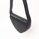 Bandolera de diseño semicircular en color negro, con correa larga ajustable y cierre superior.