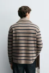Polo de punto de manga larga con cuello solapa y cierre frontal de botones. Presenta un diseño de corte regular con aberturas laterales en el bajo.