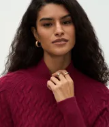Suéter de punto color crema con textura en zigzag, cuello alto y mangas largas con puños ajustados.