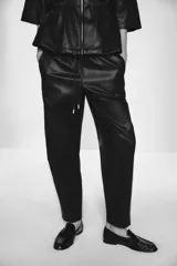 Pantalón tobillero de tiro medio color marrón oscuro, con cintura elástica ajustable con cordón y herretes dorados. Incluye bolsillos delanteros y bolsillos de plastrón en la espalda.