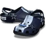 Zuecos Crocs estilo clásico con diseño de los Dallas Cowboys de la NFL, en color azul marino con detalles en celeste y blanco, con perforaciones para ventilación, tira trasera pivotante y dijes temáticos incorporados.