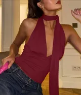 Top halter color bordó con escote profundo en V y lazada larga al cuello.