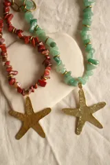 Collar con cuentas de piedra verde y dije de estrella de mar de bronce.