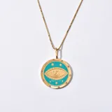 Collar con cadena dorada y dije circular con diseño de ojo turco esmaltado en celeste, rodeado de estrellas y strass.