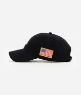 Gorra negra de algodón con visera curva, bordado frontal de la NASA en blanco y aplicación lateral de la bandera de Estados Unidos.