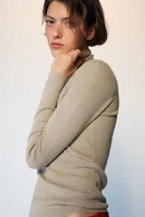 Jersey de punto con lana, color celeste, de cuello subido y manga larga, con diseño ajustado al cuerpo.