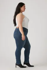 Pantalón de jean azul oscuro, tiro medio, corte ajustado y largo hasta el tobillo.