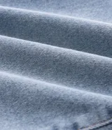 Pantalón de jean corte slim color azul claro con efecto de lavado desgastado. Cuenta con cierre frontal con botón, pasadores para cinturón y bolsillos funcionales.