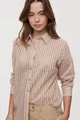 Camisa de rayas de calce relajado, confeccionada en tejido liviano y semitransparente, con cuello clásico, cierre frontal con botones, mangas largas con puños y hombros caídos.