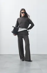 Pantalón de punto de corte relajado, con pierna recta y caída fluida. Presenta cintura con cordón ajustable y diseño minimalista.