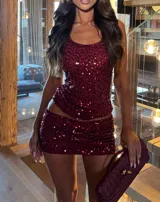 Conjunto de dos piezas compuesto por un top sin mangas y una minifalda, ambos confeccionados en tela bordada con lentejuelas color bordó.