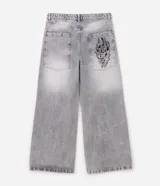 Pantalón de jean color gris claro con efecto desteñido, de corte muy ancho y holgado estilo baggy, tiro medio y bolsillos funcionales.